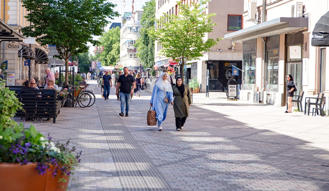 Gågata med människor i stadsmiljö.